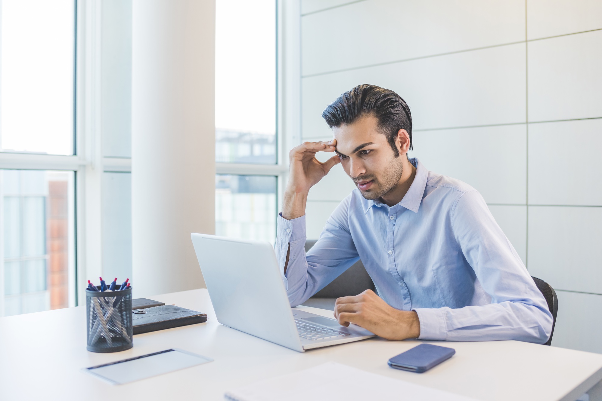 Young indian businessman using pc